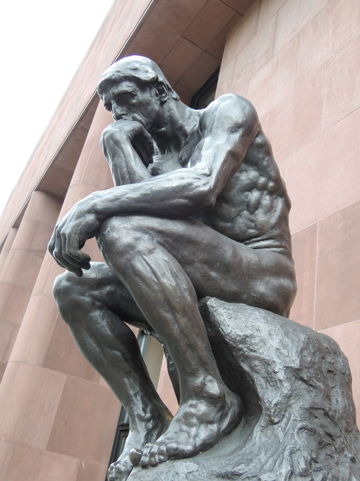 Rodin's Le Penseur (The Thinker) bronze sculpture, a seated man with chin on hand in thought